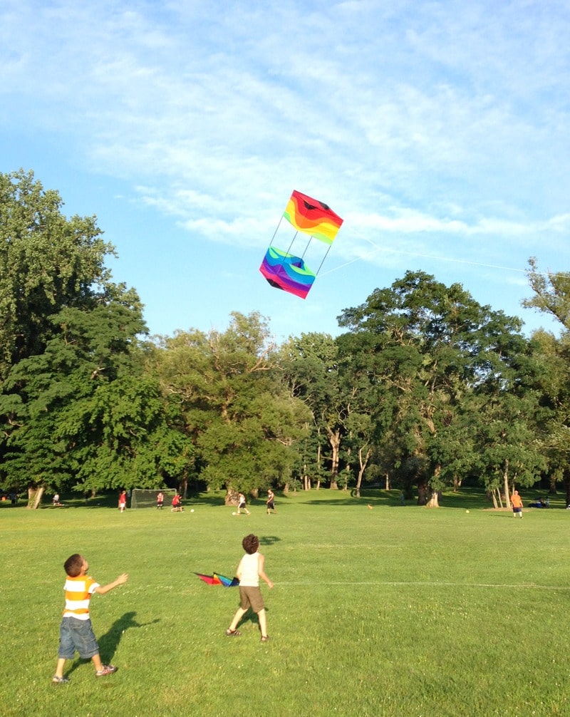 Children chasing after a brightly-colored box kite in Croton Point Park (Croton, New York).