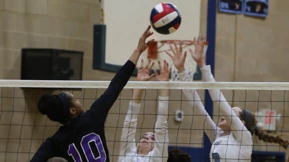 New Rochelle's Rachel Darius (10) tips the ball with Ursuline's Annie Conlon (7) and Katie McLoughlin (3) at the net during Section 1 Class AA volleyball semifinals at Ursuline School in New Rochelle Nov. 2, 2016. Ursuline defeats New Rochelle with a 25-1
