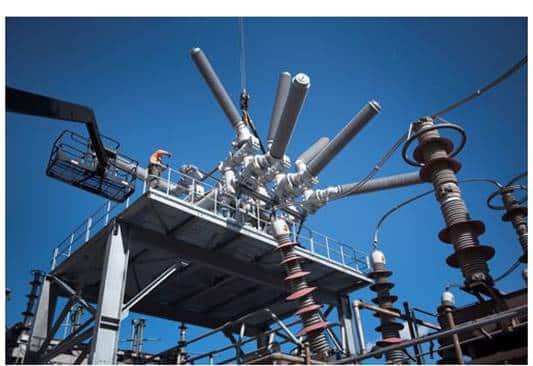 Workers installing a new 345 kV circuit breaker at a substation to allow greater system flexibility and rapid restoration during extreme weather events.