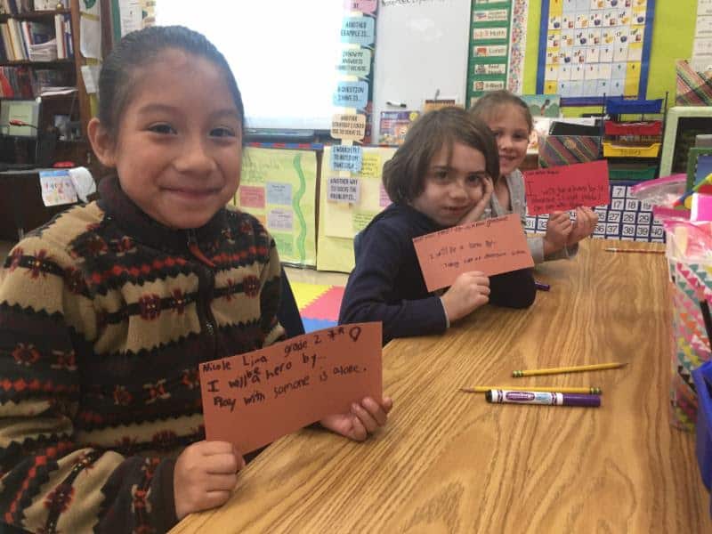 Second-graders in Victoria Treacy's class show their paper bricks on how to be heroes.