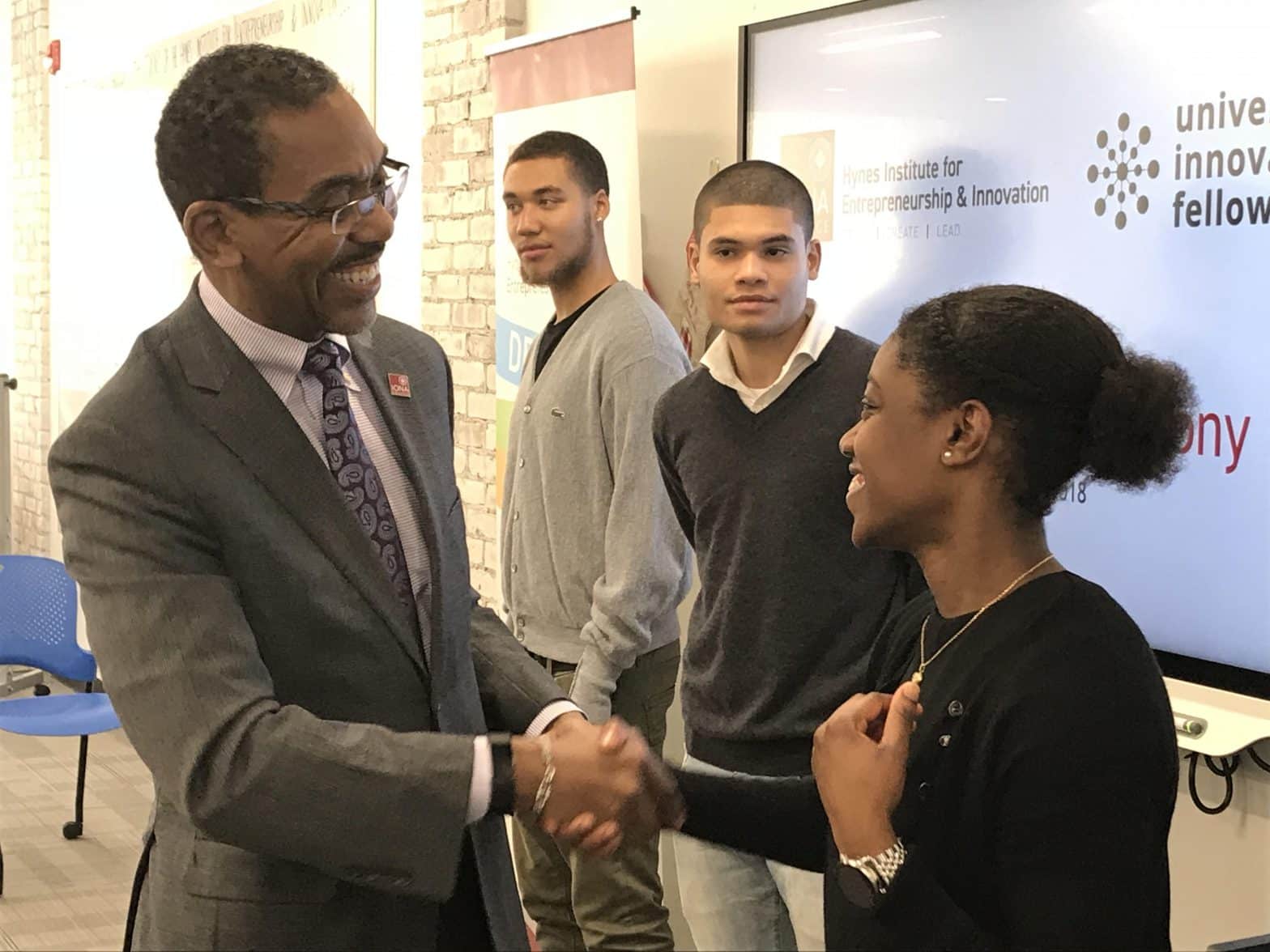 Dr. Darrell P. Wheeler, provost and senior vice president for academic affairs, presents a University Innovation Fellow pin to Tiara Griffith ‘20, a management major from Mount Vernon. Background, from left: Elijah Ware ’19, a broadcast media major from W