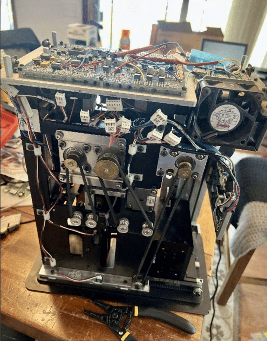 Image of a DeckMate 2 shuffler taken apart on a table, from defendant HENNEN's iCloud account.